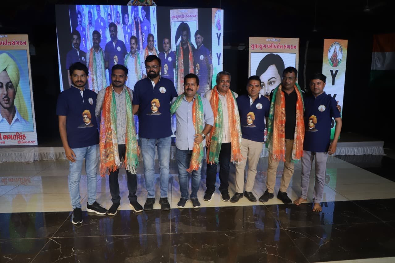 Guests and Y.Y.P members on stage wearing tricolour scarves
