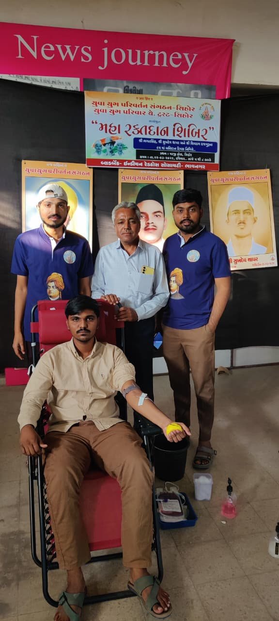 A donor giving blood with Y.Y.P members standing behind him