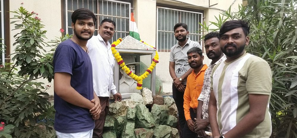 Y.Y.P members around a garlanded Bhagat Singh statue