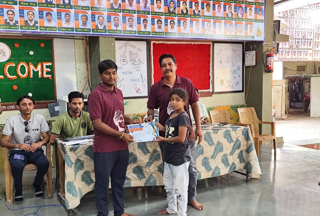 A girl receiving a karate camp certificate from Y.Y.P members