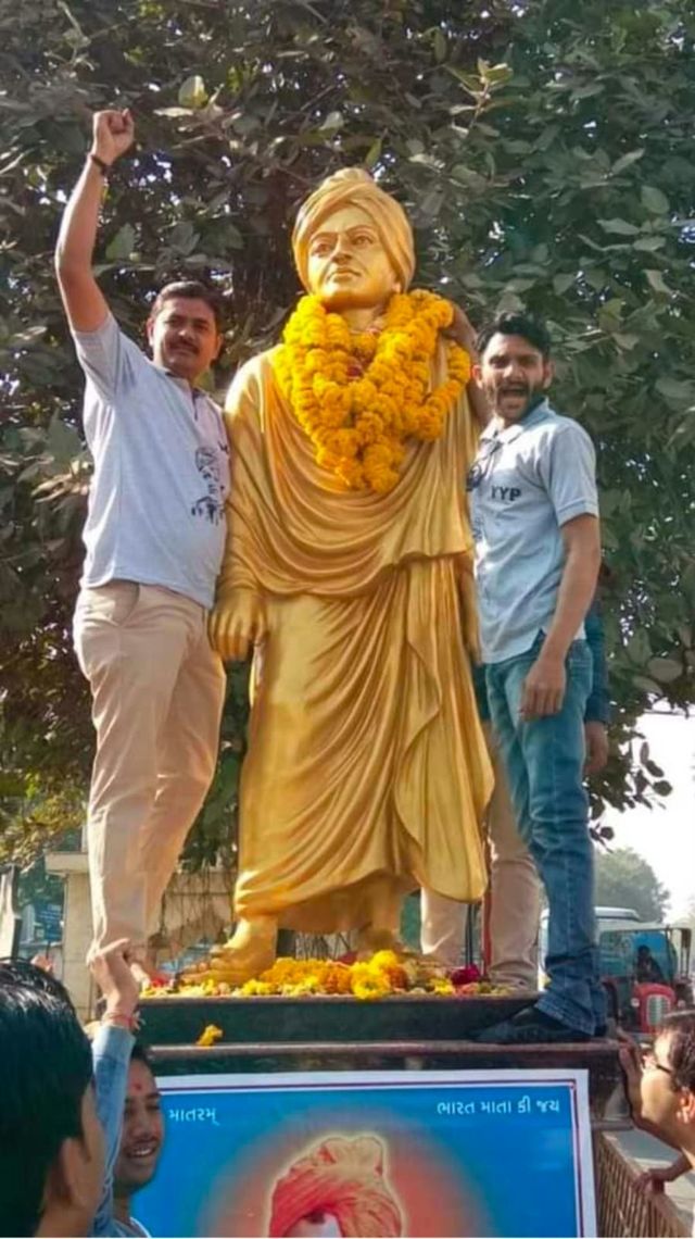 Y.Y.P member with a garlanded Swami Vivekananda statue
